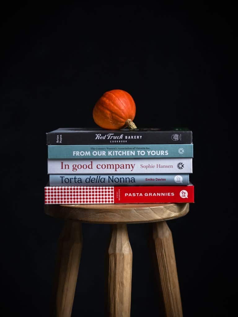 a stool with five new cookbooks i need. Pasta Grannies, From our kitchen to yours, Torta Della Nonna, In good company, Red truck Bakery