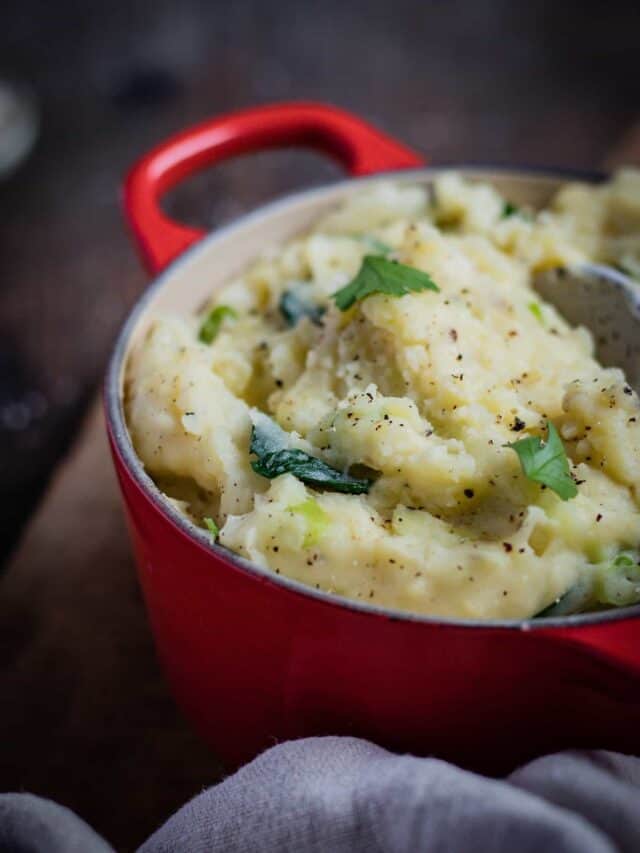 A creamy colcannon mash in a red Le Creuset pot