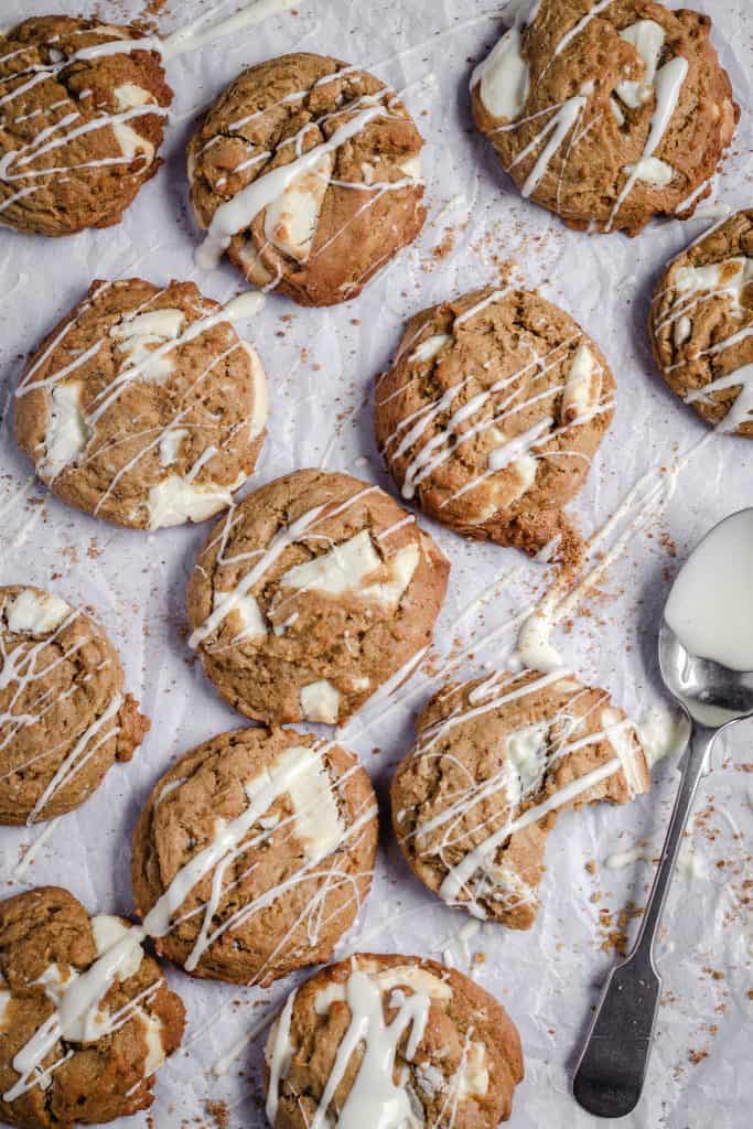 maple white chocolate chunk cookies on baking paper drizzled with melted white chocolate
