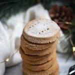 a stack of vanilla spice shortbread discs dusted with icing sugar