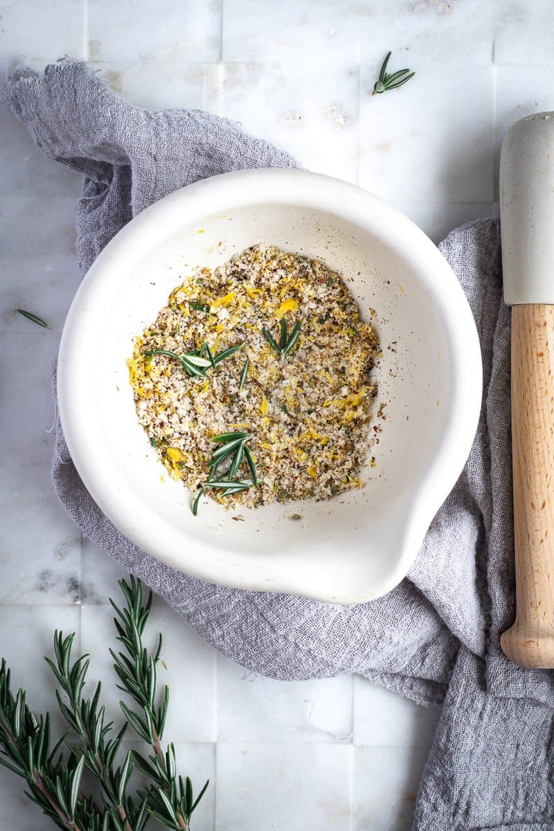 a mortar and pestle full of homemade greek spice rub on a marble bench