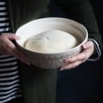Woman holding a bowl of pizza dough