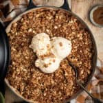 An apple and walnut crumble in a double handled shallow braiser.