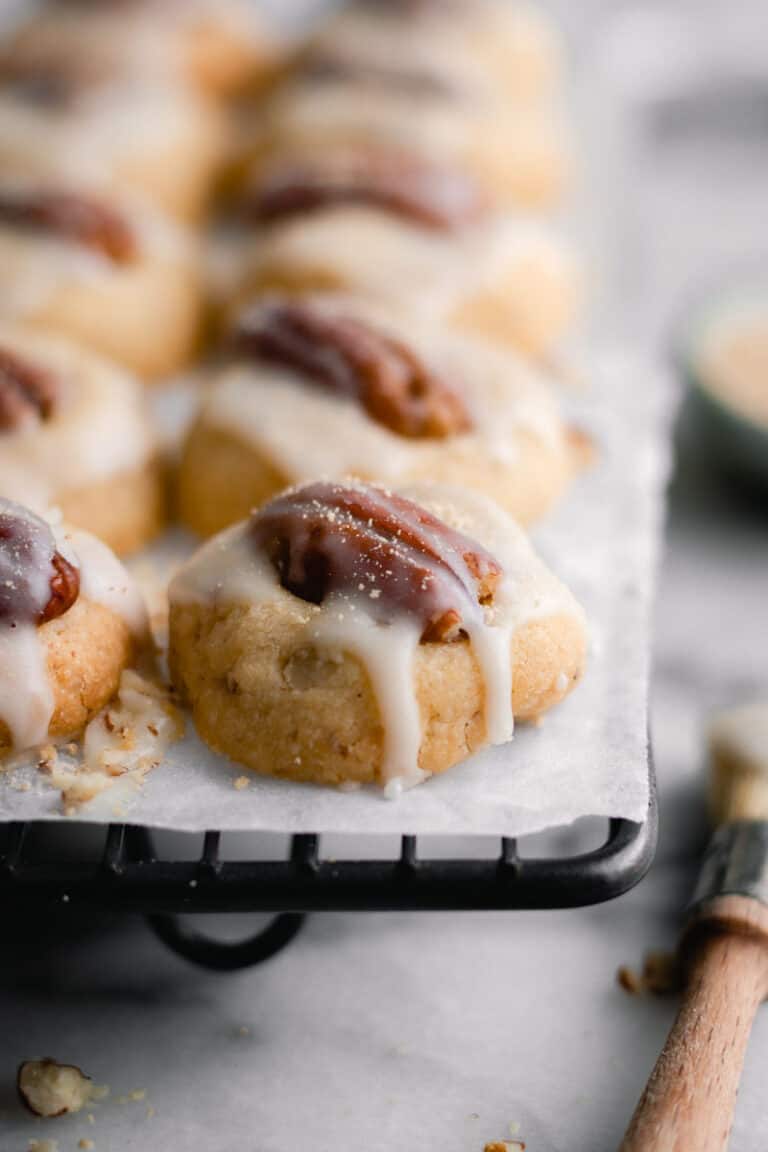 row after row of maple pecan shortbread cookies on a black baking rack.