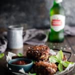 a tray of rissoles with tomato sauce on a table alongside a beef and a jug of gravy