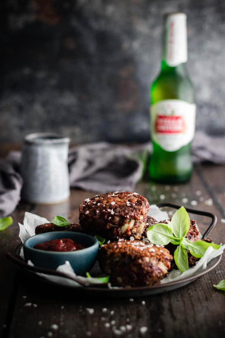 a tray of rissoles with tomato sauce on a table alongside a beef and a jug of gravy