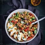 A Bowl of Freekah, fava bean and chickpea salad with sliced halloumi on top