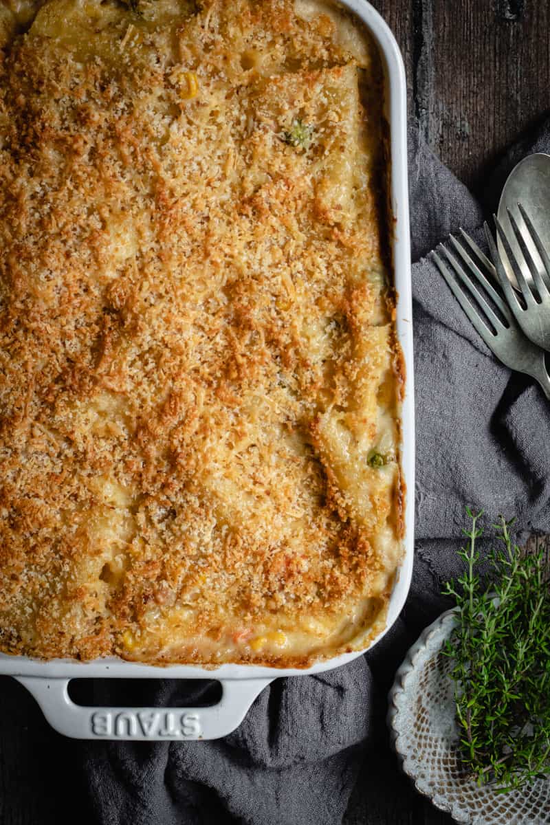 Flat lay of a creamy tuna pasta bake in a white ceramic oven dish.