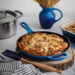 A blue cast iron skillet of savoury ham cheese and caramelized onion scrolls.