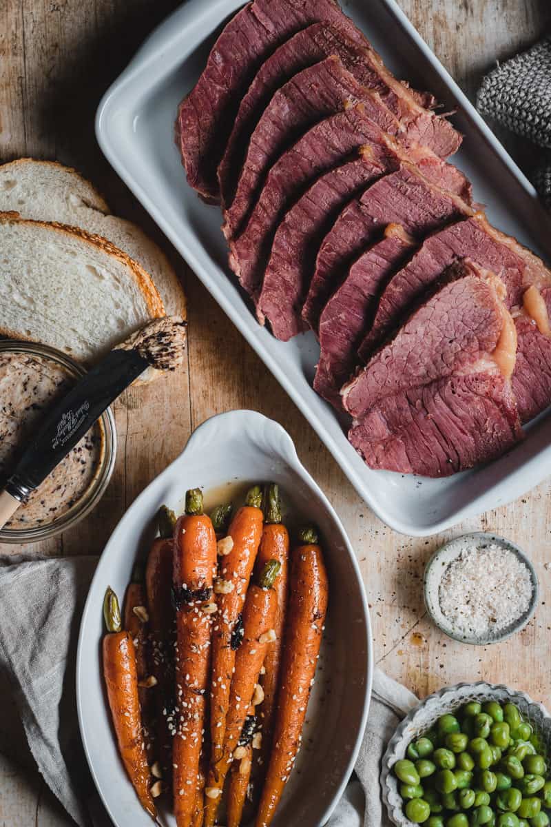 A corned beef silverside and vegetables dinner on a table.