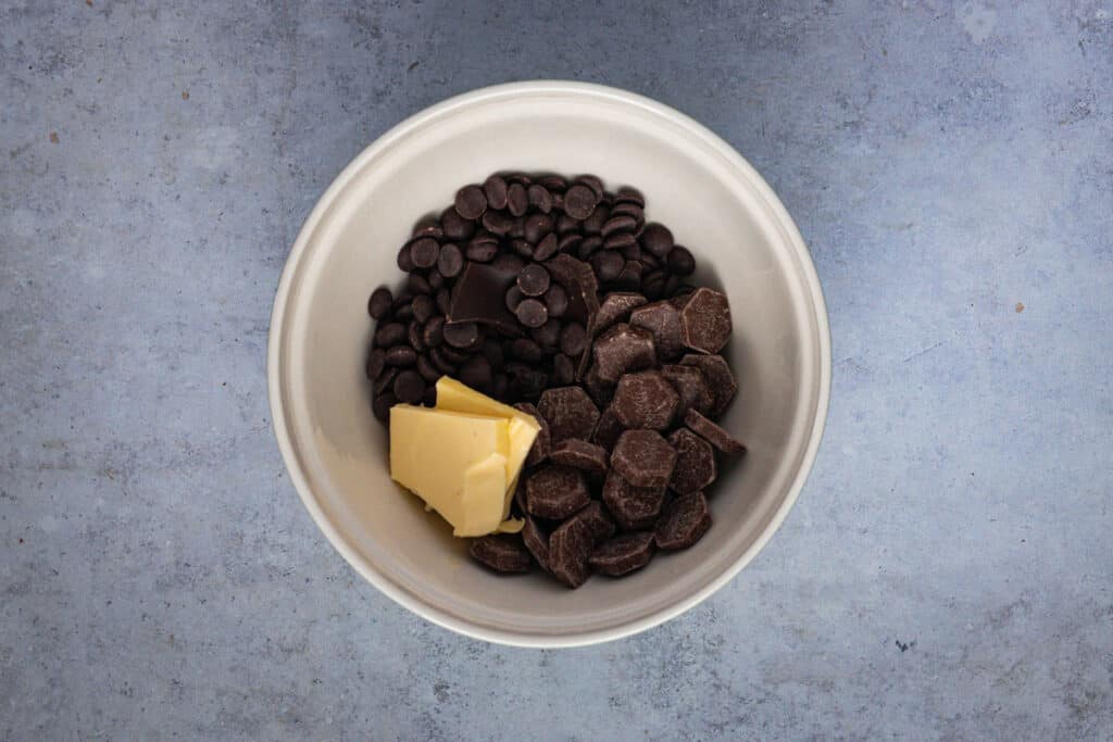 Milk chocolate, dark chocolate and butter in a bowl ready for melting.