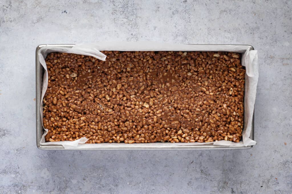 Rice bubble and Mars bar mixture pressed into a slice pan.