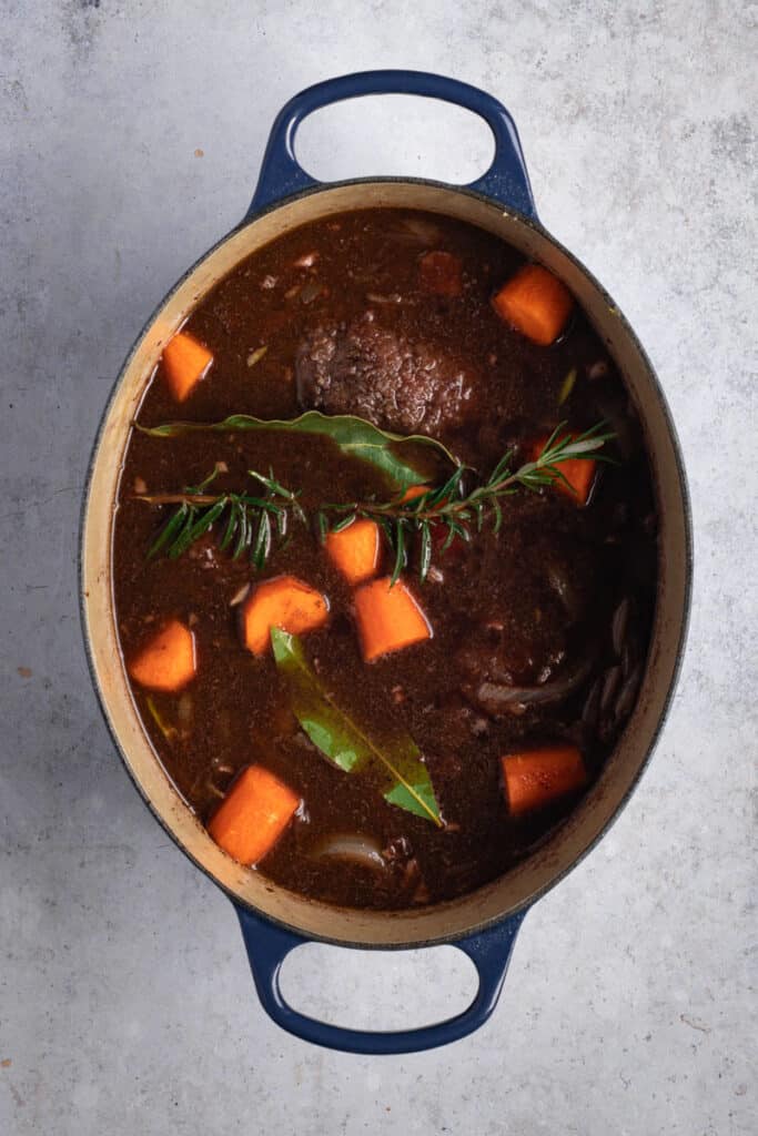 Return the beef cheeks to the pot. Add all remaining ingredients, beef stock, etc and bring to a simmer on top of the stove.