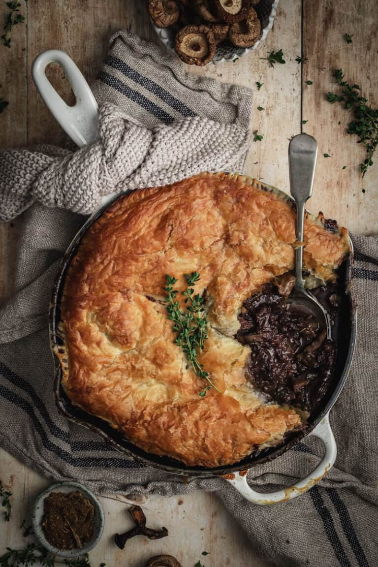 The cooked beef bourguignon pie with a serving spooned out of it.