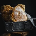 A metal tin full of golden soda bread farls.