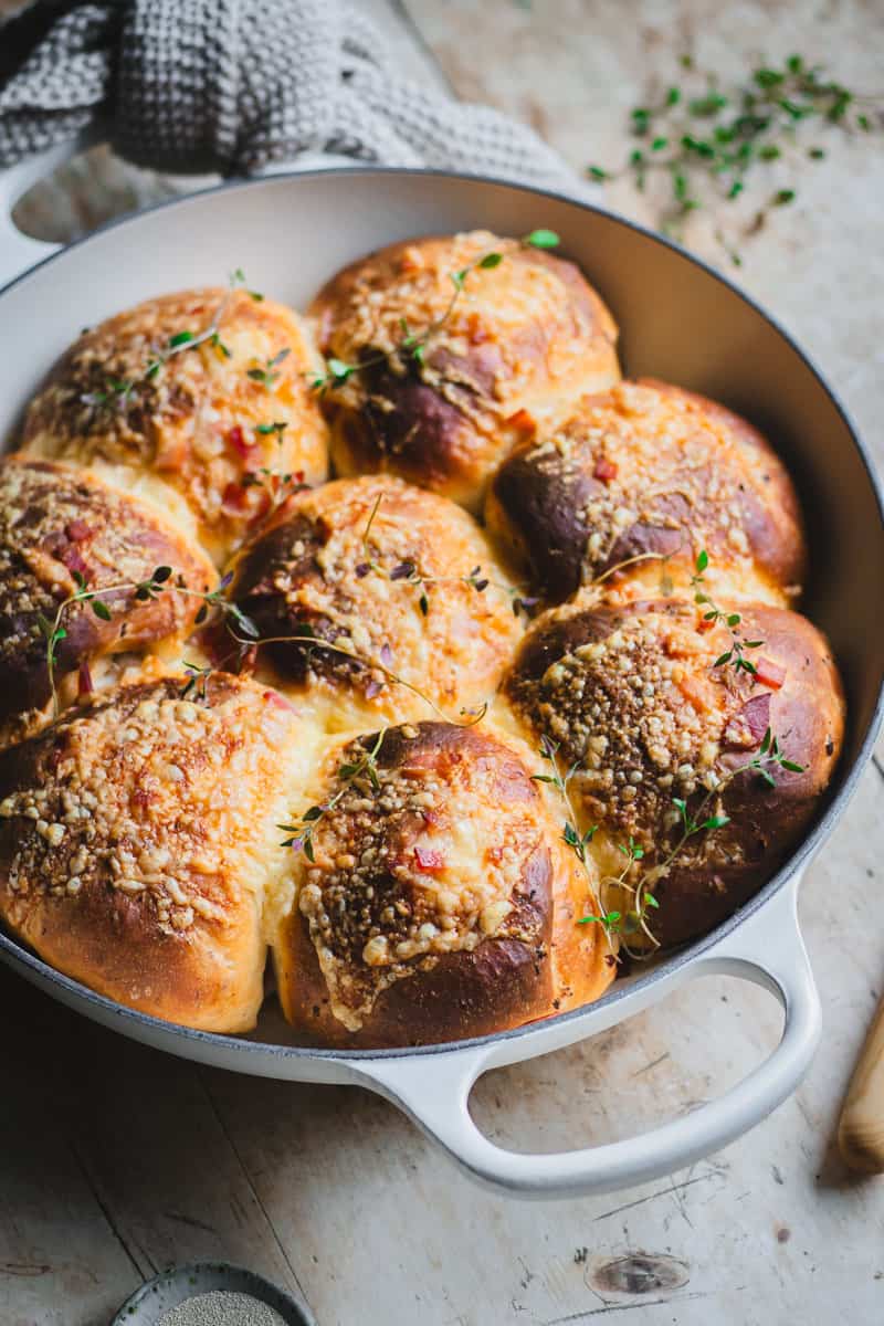 Cheese and Bacon Rolls after being taken out of the oven in a white cast iron skillet.