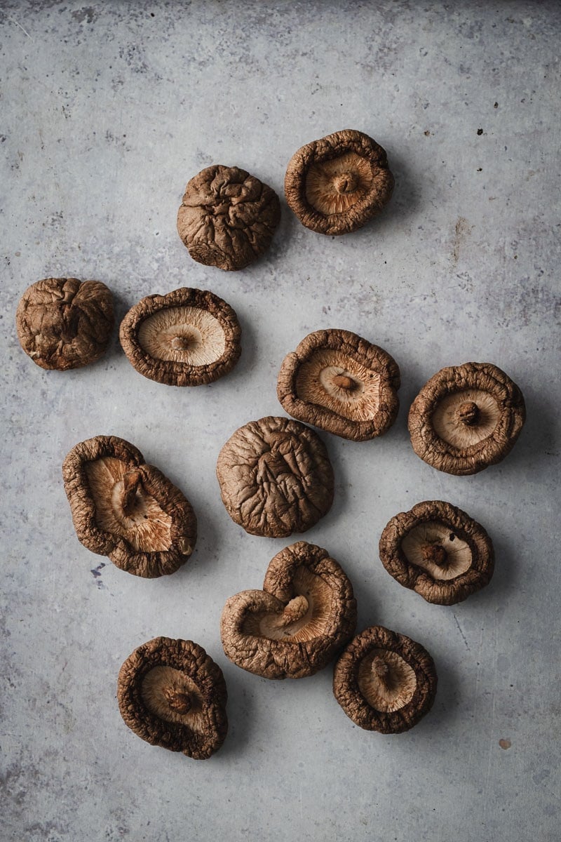 A grey bench scattered with dried shiitake mushrooms