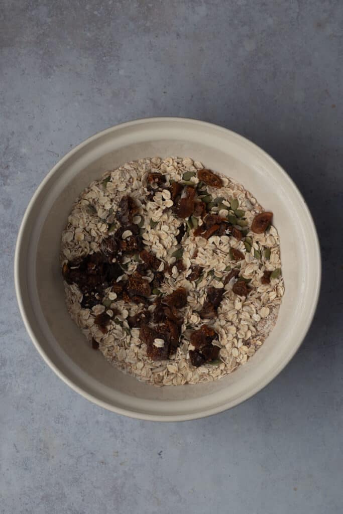 A large mason bowl full of all the dry porridge bread ingredients.