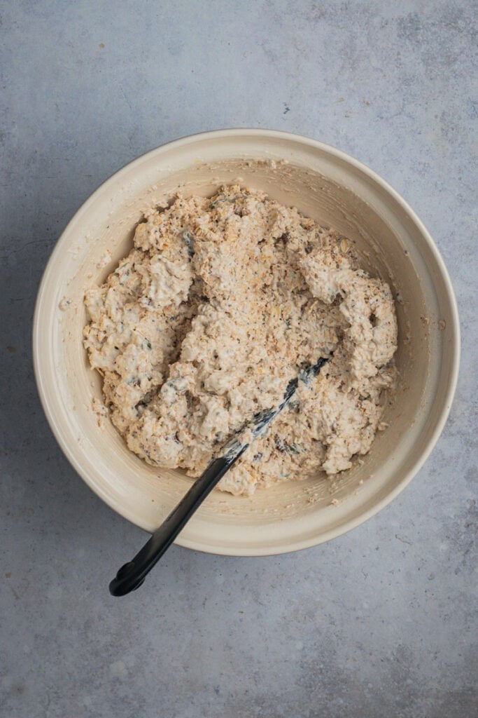 A black spatula has stirred and combined all the ingredients in the bowl.
