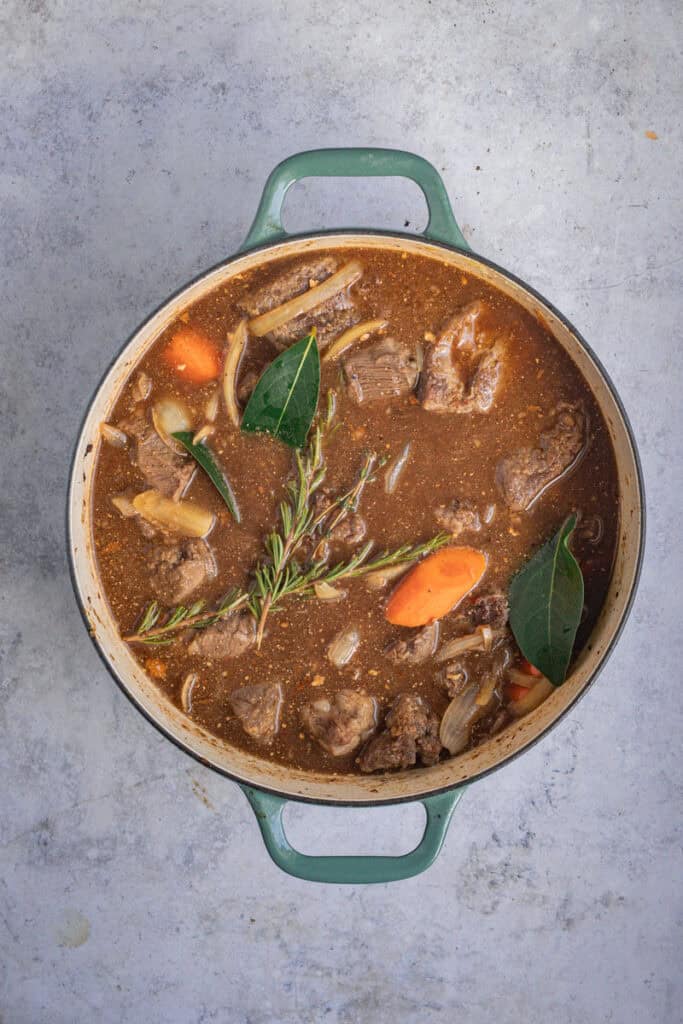 Liquid has been added along with herbs and ready for the pot to go into the oven.