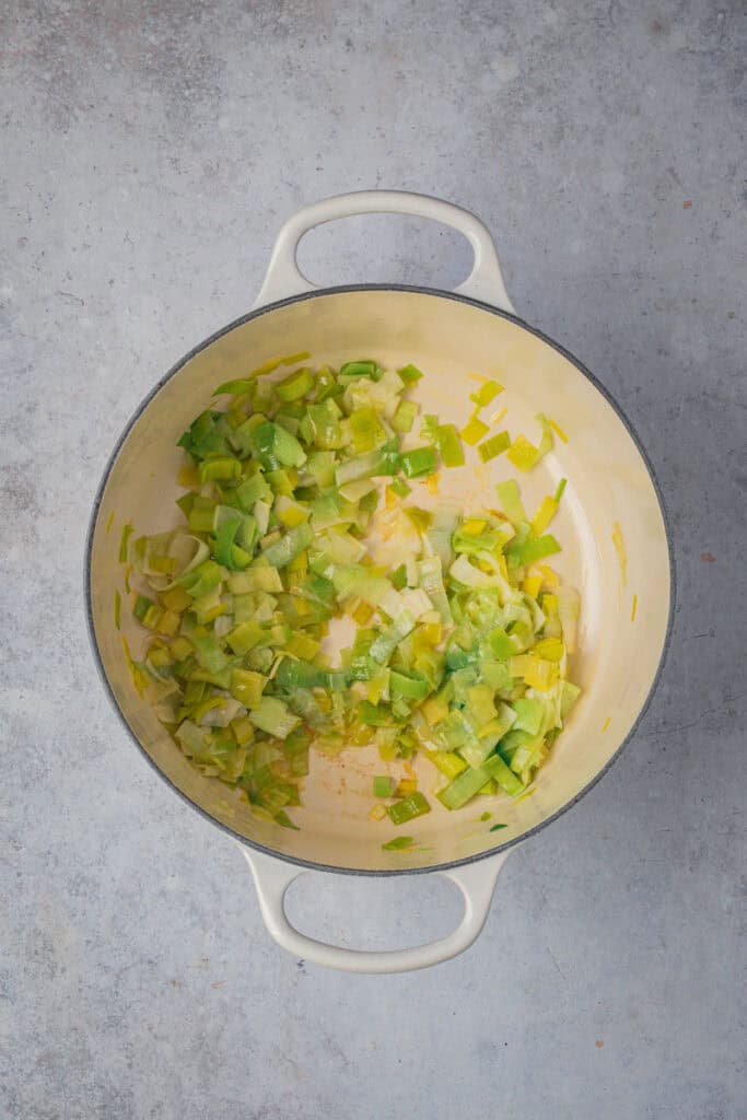 Leeks and butter sauteed in a cream enamel cast iron Dutch oven.