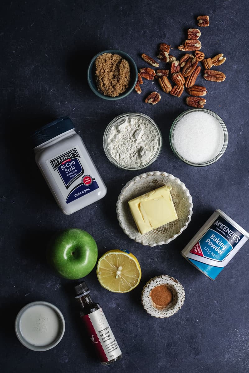 All the ingredients you need to make apple cobbler laid out on a blue background.