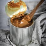 A silver can of dulce de leche with the lid peeled back revealing the creamy caramel.