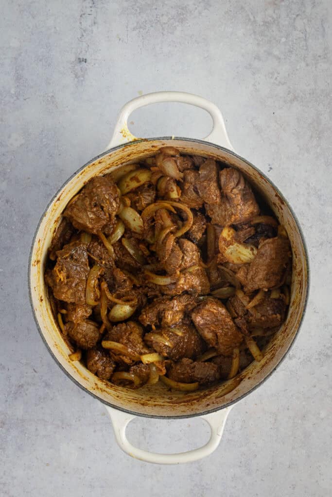 Beef is in the pot along with the onion mix.