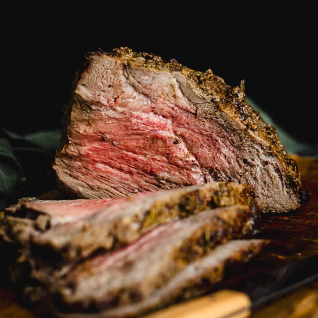 a roast topside close up cut with slices lying on the board.