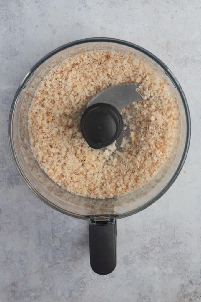 Homemade breadcrumbs in a food processor bowl.