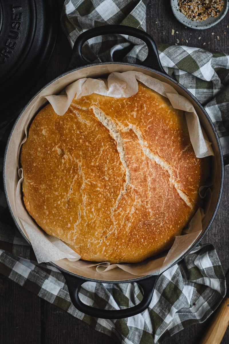 A load of Dutch oven bread in a cast iron casserole, just out of the oven.