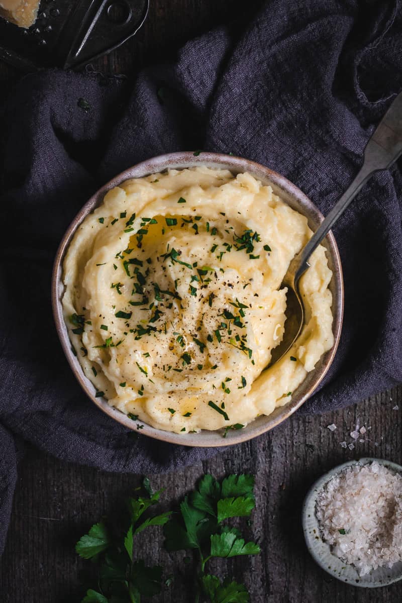Mashed potatoes with parsley and salt in a bowl.