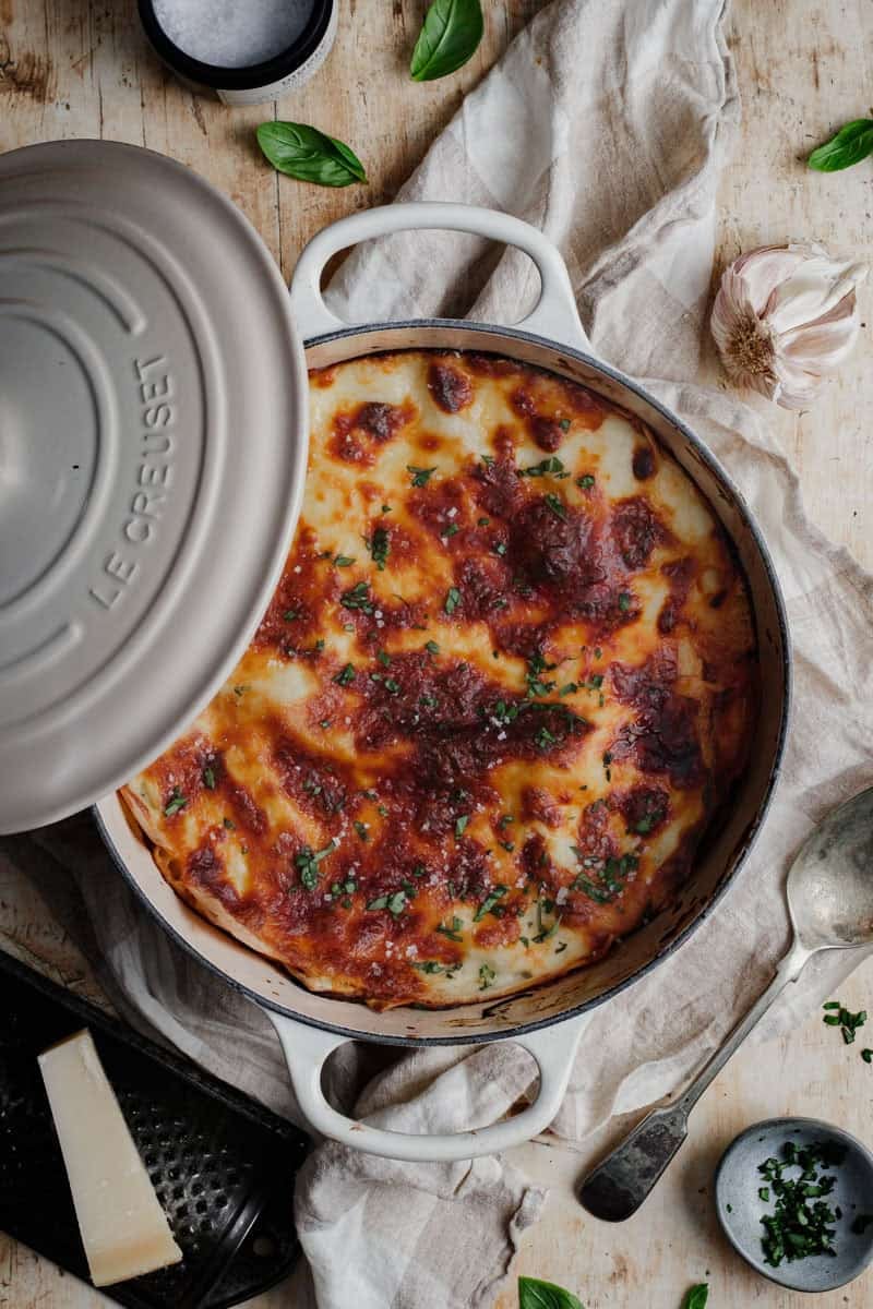 A baked cheesy lasagna cooked in an enamel Dutch oven.