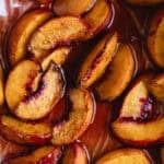 Close up of oven roast peaches on baking paper.