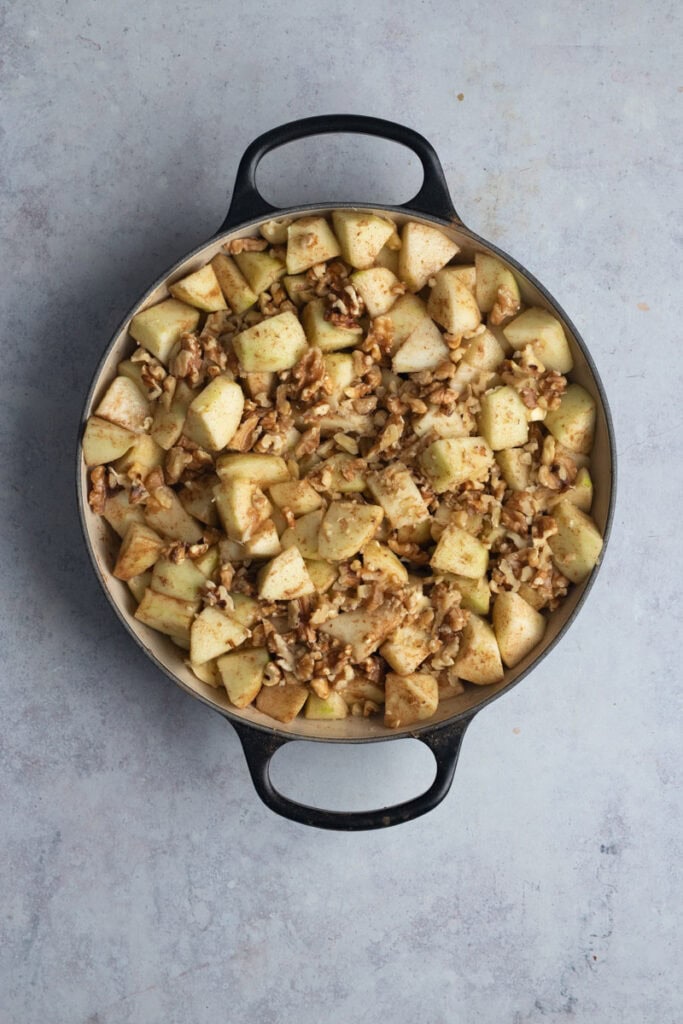 The apple and walnut mix in a two handled braiser.