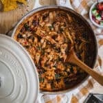 A cream enamel Dutch oven slow cooked with pulled chicken.
